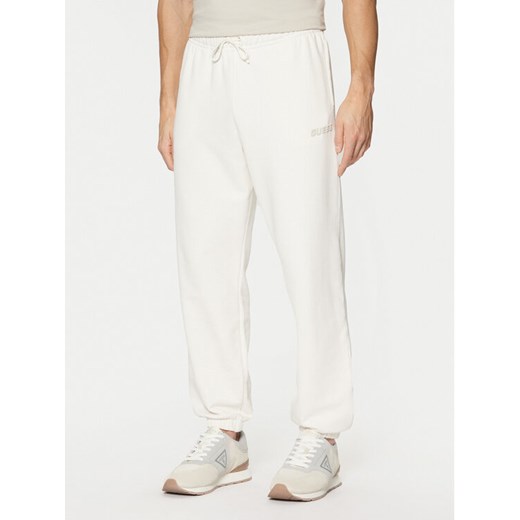 Guess Spodnie dresowe Z4YB00 KAIJ1 Écru Relaxed Fit ze sklepu MODIVO w kategorii Spodnie męskie - zdjęcie 182731402