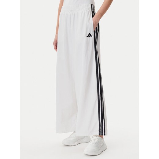 adidas Spodnie dresowe Essentials 3-Stripes JE1307 Biały Loose Fit ze sklepu MODIVO w kategorii Spodnie damskie - zdjęcie 182732481