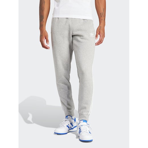 adidas Spodnie dresowe adicolor 3-Stripes IM9318 Szary Slim Fit ze sklepu MODIVO w kategorii Spodnie męskie - zdjęcie 182732704
