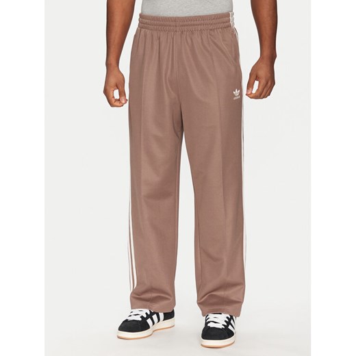 adidas Spodnie dresowe adicolor Firebird JP1067 Beżowy Baggy Fit ze sklepu MODIVO w kategorii Spodnie męskie - zdjęcie 182737712
