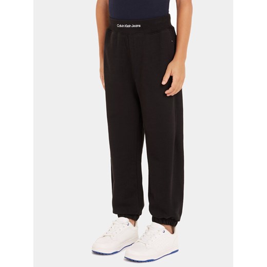 Calvin Klein Jeans Spodnie dresowe Intrasia Logo IB0IB02081 Czarny Regular Fit ze sklepu MODIVO w kategorii Spodnie chłopięce - zdjęcie 182737820