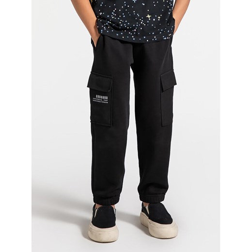 Coccodrillo Spodnie dresowe ZC4120201WBK Czarny Regular Fit ze sklepu MODIVO w kategorii Spodnie chłopięce - zdjęcie 182758140