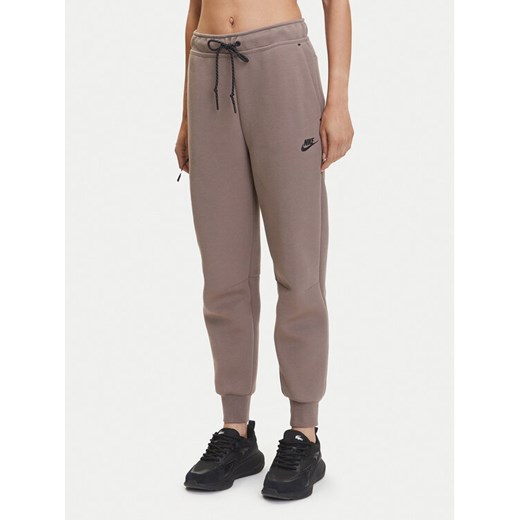 Nike Spodnie dresowe Tech Fleece HV6779 Brązowy Regular Fit ze sklepu MODIVO w kategorii Spodnie damskie - zdjęcie 183595743