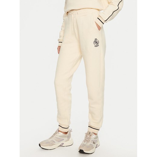 Guess Spodnie dresowe Nia V4BB06 KCHU1 Beżowy Regular Fit ze sklepu MODIVO w kategorii Spodnie damskie - zdjęcie 183612541