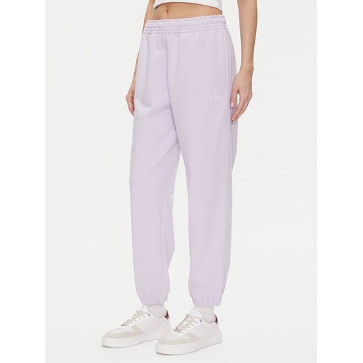 Calvin Klein Jeans Spodnie dresowe Monologo LV047B235G Fioletowy Regular Fit ze sklepu MODIVO w kategorii Spodnie damskie - zdjęcie 183706231