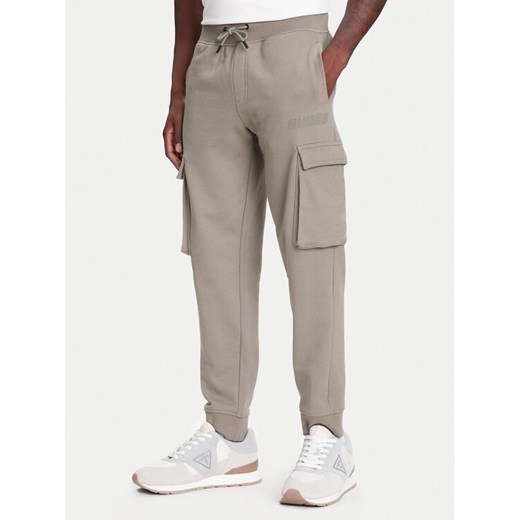 Guess Spodnie dresowe Z4YB08 KAIJ1 Khaki Regular Fit ze sklepu MODIVO w kategorii Spodnie męskie - zdjęcie 183932140