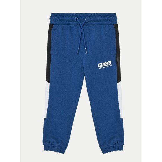 Guess Spodnie dresowe N5RQ11 KA6R4 Niebieski Relaxed Fit ze sklepu MODIVO w kategorii Spodnie chłopięce - zdjęcie 184045632
