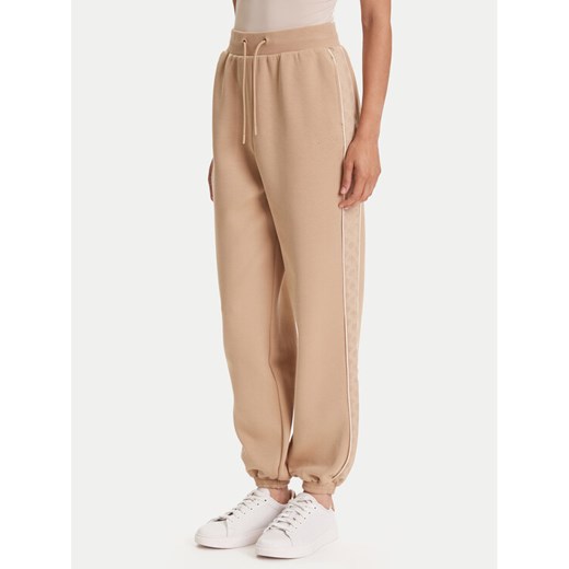 Guess Spodnie dresowe V5YB02 KB3P2 Beżowy Regular Fit ze sklepu MODIVO w kategorii Spodnie damskie - zdjęcie 184538752
