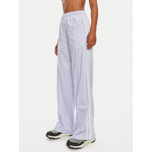 adidas Spodnie dresowe Firebird IP0643 Fioletowy Regular Fit ze sklepu MODIVO w kategorii Spodnie damskie - zdjęcie 184557552
