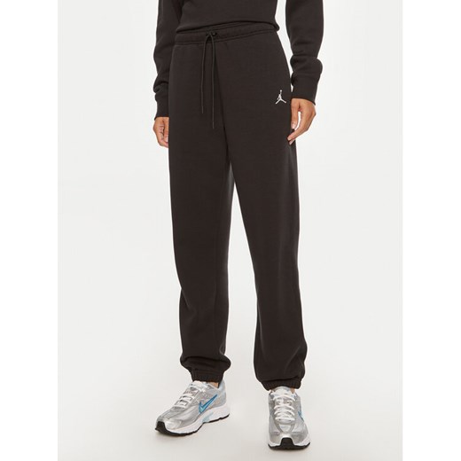 Nike Spodnie dresowe Brooklyn FN4494 Czarny Regular Fit ze sklepu MODIVO w kategorii Spodnie damskie - zdjęcie 184560672