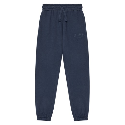 Guess Spodnie dresowe L5YQ19 KAV34 Granatowy Regular Fit ze sklepu MODIVO w kategorii Spodnie chłopięce - zdjęcie 184575400