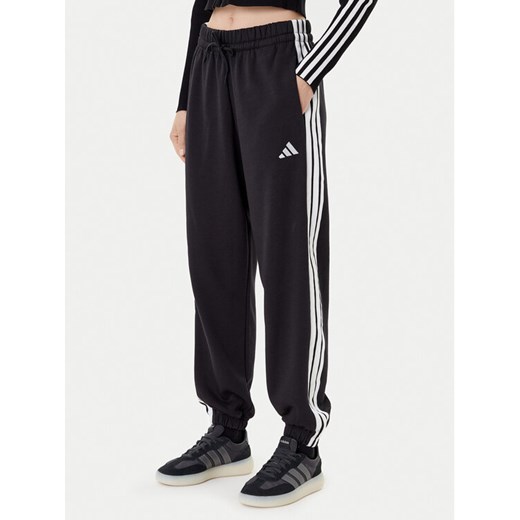 adidas Spodnie dresowe Essentials 3-Stripes Fleece JE1276 Czarny Loose Fit ze sklepu MODIVO w kategorii Spodnie damskie - zdjęcie 184920250