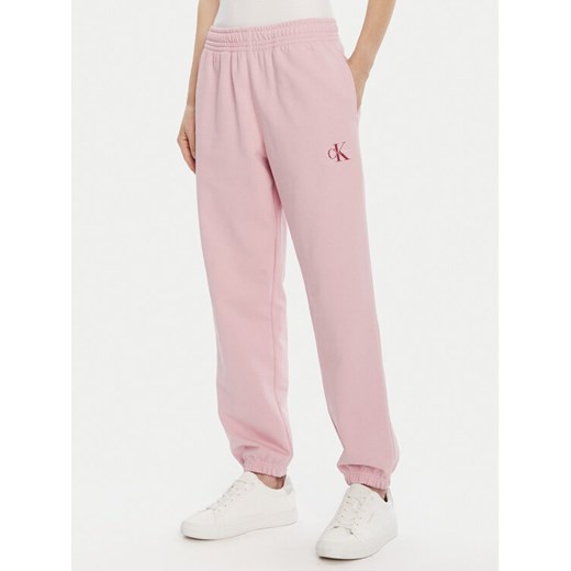 Calvin Klein Jeans Spodnie dresowe Moologo LV047B235G Różowy Regular Fit ze sklepu MODIVO w kategorii Spodnie damskie - zdjęcie 185466332