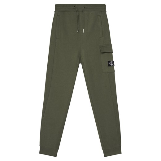 Calvin Klein Jeans Spodnie dresowe Badge IB0IB02199 Zielony Relaxed Fit ze sklepu MODIVO w kategorii Spodnie chłopięce - zdjęcie 185761562