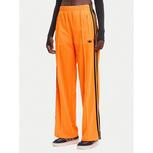 adidas Spodnie dresowe adicolor Classic Firebird JY2694 Żółty Loose Fit ze sklepu MODIVO w kategorii Spodnie damskie - zdjęcie 185913110