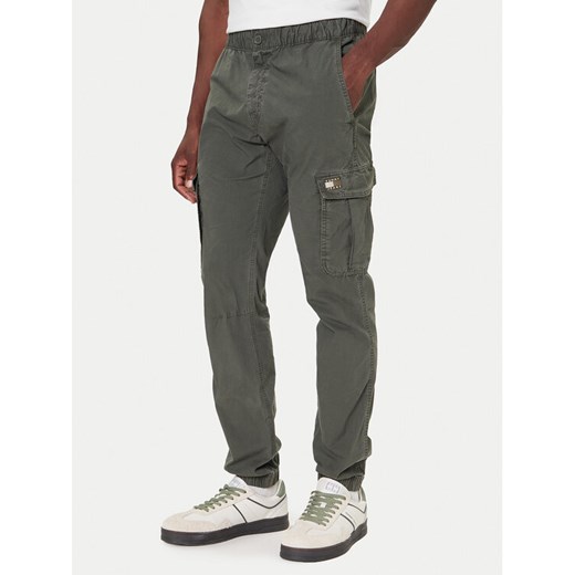 Tommy Jeans Spodnie materiałowe DM0DM22003 Zielony Regular Fit ze sklepu MODIVO w kategorii Spodnie męskie - zdjęcie 186267633