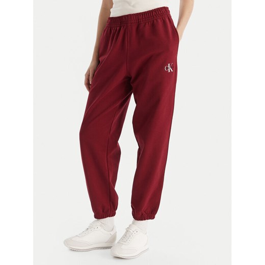 Calvin Klein Jeans Spodnie dresowe Monologo LV047B235G Bordowy Regular Fit ze sklepu MODIVO w kategorii Spodnie damskie - zdjęcie 186379132