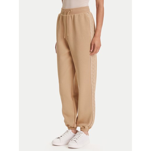 Guess Spodnie dresowe V5YB02 KB3P2 Beżowy Regular Fit ze sklepu MODIVO w kategorii Spodnie damskie - zdjęcie 186484191