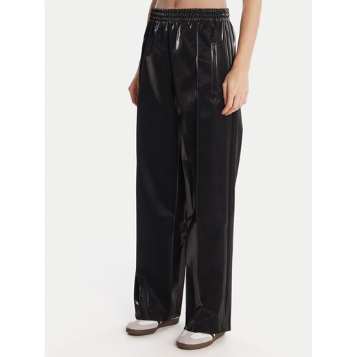 adidas Spodnie dresowe adicolor Holiday JV7503 Czarny Loose Fit ze sklepu MODIVO w kategorii Spodnie damskie - zdjęcie 186806373