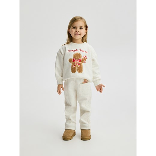 Reserved - Spodnie ze świąteczną aplikacją - złamana biel ze sklepu Reserved w kategorii Spodnie dziewczęce - zdjęcie 187341203