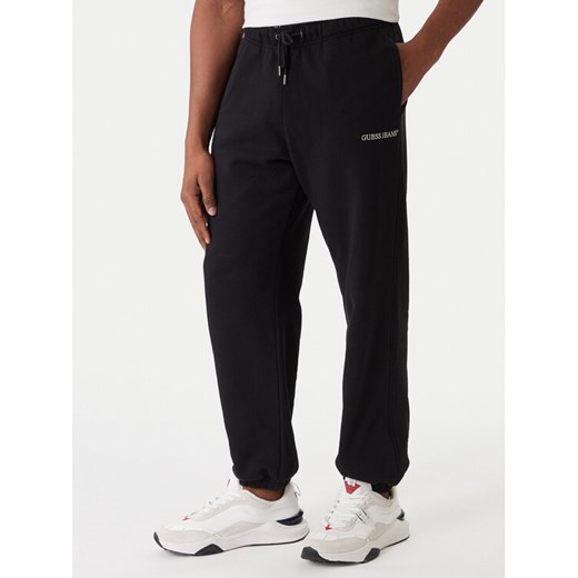 Guess Jeans Spodnie dresowe M6RB70 KCPR1 Czarny Regular Fit ze sklepu MODIVO w kategorii Spodnie męskie - zdjęcie 187516434