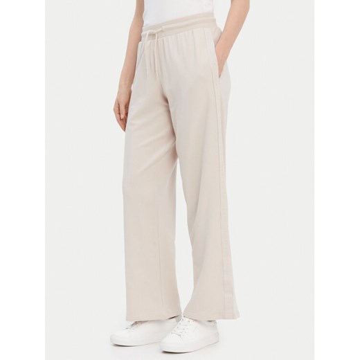 Tommy Hilfiger Spodnie dresowe UW0UW04771 Beżowy Relaxed Fit ze sklepu MODIVO w kategorii Spodnie damskie - zdjęcie 187543244