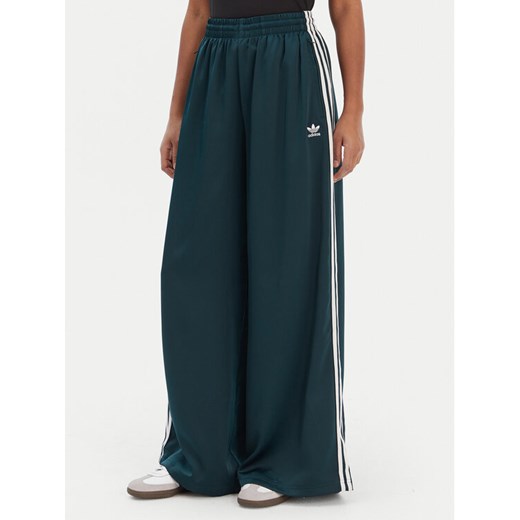 adidas Spodnie dresowe adicolor Satin JV7511 Zielony Wide Leg ze sklepu MODIVO w kategorii Spodnie damskie - zdjęcie 187673252