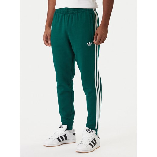 adidas Spodnie dresowe 3-Stripes KE3559 Zielony Slim Fit ze sklepu MODIVO w kategorii Spodnie męskie - zdjęcie 187828152
