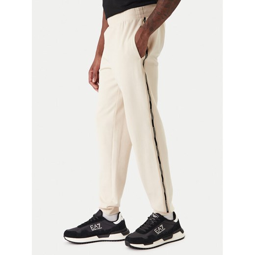 EA7 Emporio Armani Spodnie dresowe 7M001482 AF12660 U1088 Beżowy Regular Fit ze sklepu MODIVO w kategorii Spodnie męskie - zdjęcie 187934142