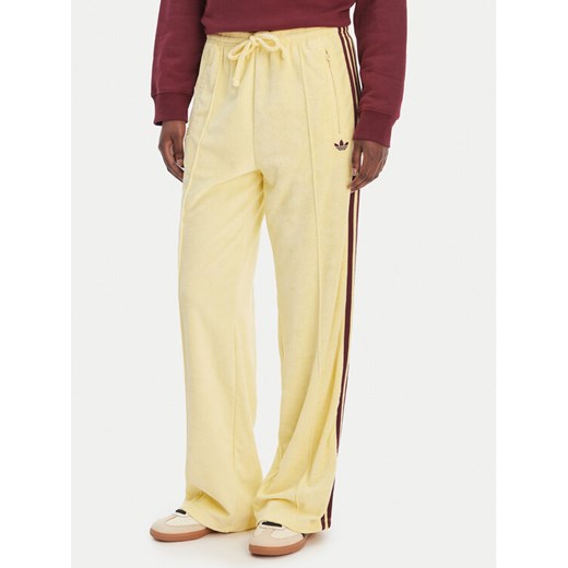 adidas Spodnie dresowe Terry Towel Firebird KQ6662 Żółty Loose Fit ze sklepu MODIVO w kategorii Spodnie damskie - zdjęcie 189346511