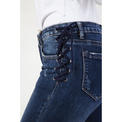 Spodnie jeansowe z wiązaniami z boku i szarpaniami na dole   M olika.com.pl