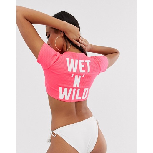 ASOS DESIGN – Neonowo-różowy plażowy top o skróconym kroju z prążkowanego dżerseju z ozdobnym węzłem na przodzie i napisem „wet 'n' wild”