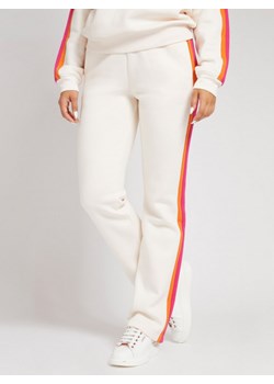 Damskie spodnie dresowe GUESS BRANDIE LONG PANT - kremowe/ecru ze sklepu Sportstylestory.com w kategorii Spodnie damskie - zdjęcie 135205760