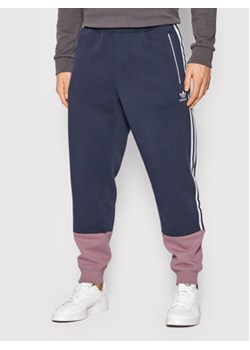 adidas Spodnie dresowe Sst Fleece Track HC2083 Granatowy Regular Fit ze sklepu MODIVO w kategorii Spodnie męskie - zdjęcie 152678071