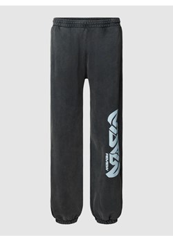 Spodnie dresowe z nadrukiem z logo model ‘GOTHIC’ — REVIEW x MATW ze sklepu Peek&Cloppenburg  w kategorii Spodnie męskie - zdjęcie 162395543