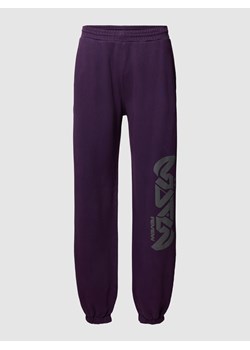Spodnie dresowe z nadrukiem z logo model ‘GOTHIC’ — REVIEW x MATW ze sklepu Peek&Cloppenburg  w kategorii Spodnie męskie - zdjęcie 162404114