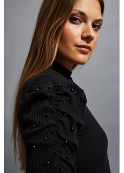 Prążkowana bluzka z bufiastymi rękawami i półgolfem czarna ze sklepu Moodo.pl w kategorii Bluzki damskie - zdjęcie 162543562