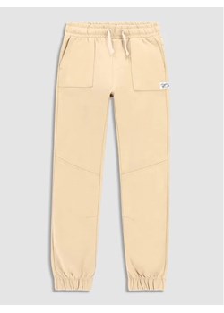 Coccodrillo Spodnie materiałowe WC3120103SKJ Beżowy Slim Fit ze sklepu MODIVO w kategorii Spodnie dziewczęce - zdjęcie 168406204
