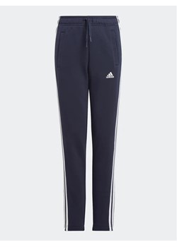 adidas Spodnie dresowe Essentials 3-Stripes IC6128 Granatowy Slim Fit ze sklepu MODIVO w kategorii Spodnie chłopięce - zdjęcie 168409341