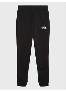 The North Face Spodnie dresowe Teen NF0A82EO Czarny Regular Fit ze sklepu MODIVO w kategorii Spodnie chłopięce - zdjęcie 168443351