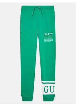 Guess Spodnie dresowe J3YQ11 KA6R4 Zielony Regular Fit ze sklepu MODIVO w kategorii Spodnie chłopięce - zdjęcie 168500950