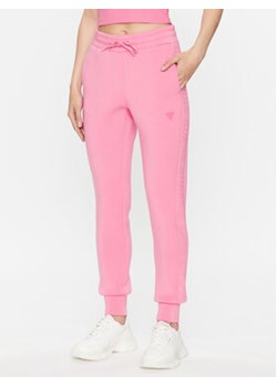 Guess Spodnie dresowe V2YB18 K7UW2 Różowy Reglan Fit ze sklepu MODIVO w kategorii Spodnie damskie - zdjęcie 168505571