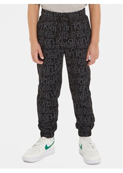 Calvin Klein Jeans Spodnie dresowe Glow In The Dark IB0IB01896 Czarny Regular Fit ze sklepu MODIVO w kategorii Spodnie chłopięce - zdjęcie 168527944