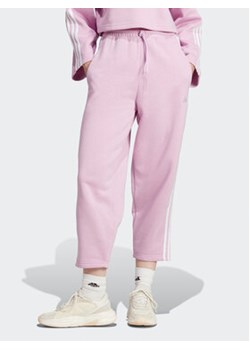 adidas Spodnie dresowe Essentials 3-Stripes Open Hem Fleece IJ7455 Różowy Loose Fit ze sklepu MODIVO w kategorii Spodnie damskie - zdjęcie 168547071