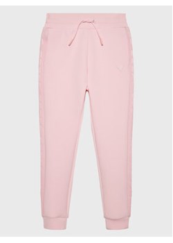 Guess Spodnie dresowe J2YQ24 FL03S Różowy Relaxed Fit ze sklepu MODIVO w kategorii Spodnie dziewczęce - zdjęcie 168562962
