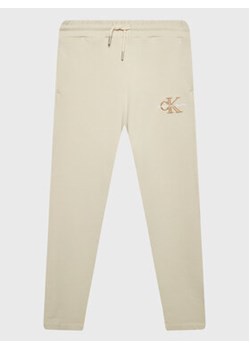 Calvin Klein Jeans Spodnie dresowe Monogram Off Placed IG0IG01607 Écru Regular Fit ze sklepu MODIVO w kategorii Spodnie chłopięce - zdjęcie 168572590