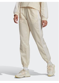 adidas Spodnie dresowe adicolor lassics Poplin Track HL9309 Écru Regular Fit ze sklepu MODIVO w kategorii Spodnie damskie - zdjęcie 168579572