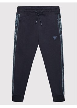 Guess Spodnie dresowe L2YQ48 K6ZS1 Granatowy Regular Fit ze sklepu MODIVO w kategorii Spodnie chłopięce - zdjęcie 168582131
