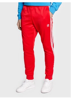 adidas Spodnie dresowe adicolor Classics Primeblue HF2134 Czerwony Slim Fit ze sklepu MODIVO w kategorii Spodnie męskie - zdjęcie 168582351