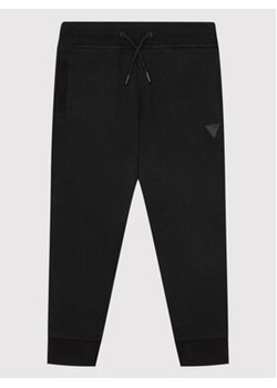 Guess Spodnie dresowe L2YQ46 KAIJ1 Czarny Regular Fit ze sklepu MODIVO w kategorii Spodnie chłopięce - zdjęcie 168596810